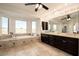Bright bathroom features a corner tub, dark cabinets, a large mirror, and many windows providing natural light at 5528 E Windstone Trl, Cave Creek, AZ 85331