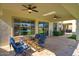 Covered patio with a glass top dining table and chairs, views of the pool and green backyard at 5528 E Windstone Trl, Cave Creek, AZ 85331