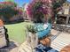 Inviting outdoor seating area with artificial grass, blooming flowers, and privacy wall at 758 S Lagoon Dr, Gilbert, AZ 85233