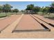 Outdoor bocce ball court surrounded by grass and shade trees in a park at 758 S Lagoon Dr, Gilbert, AZ 85233