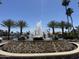 Water fountain featuring decorative stones and palm trees with waterfront homes in the background at 758 S Lagoon Dr, Gilbert, AZ 85233