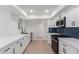 Modern white kitchen with quartz countertops and stainless steel appliances at 10127 W Forrester Dr, Sun City, AZ 85351