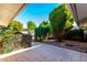 Backyard patio with tile flooring and lush landscaping at 10127 W Forrester Dr, Sun City, AZ 85351