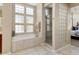 Bathroom features a large soaking tub, glass shower, and a view into the bedroom at 13036 W Fetlock Trl, Peoria, AZ 85383