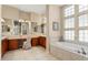 Elegant bathroom with double vanities, a large soaking tub, and a separate shower at 13036 W Fetlock Trl, Peoria, AZ 85383