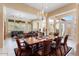 Open dining room with chandelier and view into living room at 13036 W Fetlock Trl, Peoria, AZ 85383