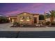 Beautiful desert home exterior at sunset; stone accents and landscaped yard at 13036 W Fetlock Trl, Peoria, AZ 85383
