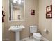 Elegant powder room with pedestal sink and updated toilet at 13036 W Fetlock Trl, Peoria, AZ 85383