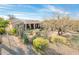 Well-maintained backyard features desert landscaping and covered patio with lighting at 18932 N Aztec Point Dr, Surprise, AZ 85387