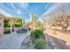 This backyard with desert landscaping features a built-in fireplace and gravel walkways at 18932 N Aztec Point Dr, Surprise, AZ 85387