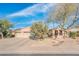Inviting home exterior showcasing a well-manicured front yard with mature trees and a two-car garage at 18932 N Aztec Point Dr, Surprise, AZ 85387