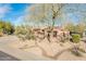Charming home showcasing desert landscaping, mature trees, and a well-maintained front yard at 18932 N Aztec Point Dr, Surprise, AZ 85387