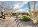 Charming single-story home with desert landscaping, mature trees, and a covered porch entry at 18932 N Aztec Point Dr, Surprise, AZ 85387