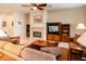 Spacious living room with a fireplace, built-in media center, tile flooring, and comfortable seating at 18932 N Aztec Point Dr, Surprise, AZ 85387