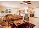 Open-concept living room with tile flooring, comfortable seating, and seamless flow to the dining area and kitchen at 18932 N Aztec Point Dr, Surprise, AZ 85387