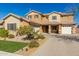 Beautiful two-story home featuring a three car garage, neutral desert color palette and manicured front yard at 20562 E Raven Dr, Queen Creek, AZ 85142