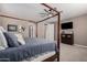 Main bedroom with a canopy bed and a large TV at 20562 E Raven Dr, Queen Creek, AZ 85142