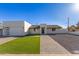 Modern home exterior with artificial turf, a paver driveway, and a two-car garage at 2129 S Los Feliz Dr, Tempe, AZ 85282