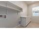 Laundry room with white cabinets, countertop, and open shelving at 2129 S Los Feliz Dr, Tempe, AZ 85282