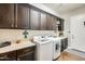Bright laundry room, features dark wood cabinets, washer, dryer, and ample counter space at 2238 E Saddlebrook Rd, Gilbert, AZ 85298