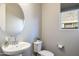 Clean bathroom with white sink, toilet and oval mirror at 27165 N 71St Ln, Peoria, AZ 85383