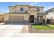 Two-story house with tan exterior, large garage, and landscaped front yard at 27165 N 71St Ln, Peoria, AZ 85383