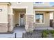 Front porch with stone pillars, a blue door, and seasonal decorations at 27165 N 71St Ln, Peoria, AZ 85383