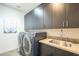 Modern laundry room with dark cabinetry and new appliances at 30 W Palm Ln, Phoenix, AZ 85003