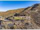 Aerial view of a luxurious house nestled in the mountains with a long driveway at 37300 N School House Rd, Cave Creek, AZ 85331