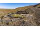 Aerial view of a luxury house on a hillside with a curved driveway at 37300 N School House Rd, Cave Creek, AZ 85331