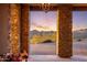 Stunning sunset view framed by stone columns from entryway at 37300 N School House Rd, Cave Creek, AZ 85331