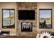 Living room features a stone fireplace, large TV, and stunning mountain views at 37300 N School House Rd, Cave Creek, AZ 85331