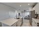 Modern kitchen with white cabinets, island, and stainless steel appliances at 4428 N 92Nd Ln, Phoenix, AZ 85037