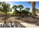 Backyard with desert landscape, rock ground covering, trees and brick-lined patio at 4615 W Corral Rd, Laveen, AZ 85339