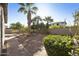 Inviting backyard oasis with mature palm trees, lush greenery, desert foliage, and brick pathway at 4615 W Corral Rd, Laveen, AZ 85339