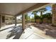 Large covered patio opens to a xeriscaped backyard with mature trees and a built in BBQ at 4615 W Corral Rd, Laveen, AZ 85339