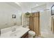 Well-lit bathroom with a toilet, shower with tan curtain, and a large vanity at 4615 W Corral Rd, Laveen, AZ 85339