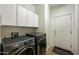 Laundry room featuring front-load washer and dryer with white cabinets above and a door to the exterior at 4615 W Corral Rd, Laveen, AZ 85339