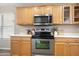 A well-lit kitchen with stainless steel appliances, light wood cabinetry, and ample counter space at 631 E Banelli Pl, Chandler, AZ 85286