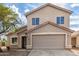 Two-story house with tan exterior, two-car garage, and landscaping at 6537 W Riva Rd, Phoenix, AZ 85043
