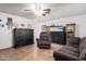 Living room featuring a ceiling fan, brown furniture and storage at 7137 W Mercer Ln, Peoria, AZ 85345