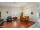 Dining area with hardwood floors and wood table, adjacent to living room at 11503 W Cyprus Dr, Avondale, AZ 85392