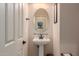 Small bathroom with pedestal sink and oval mirror at 117 E Blue Lagoon Dr, Casa Grande, AZ 85122