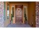 Inviting entryway with a wood door and potted plants at 117 E Blue Lagoon Dr, Casa Grande, AZ 85122