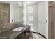 Modern bathroom with dark vanity, mosaic tile, and glass block window at 11850 E Del Timbre Dr, Scottsdale, AZ 85259