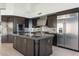 Modern kitchen with dark cabinetry, stainless steel appliances, and an island at 11850 E Del Timbre Dr, Scottsdale, AZ 85259