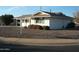 Charming front exterior with well-maintained desert landscape and white painted brick at 12001 N Pebble Beach Dr, Sun City, AZ 85351