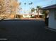 Street view of single-story home with desert landscaping and scattered palm trees at 12001 N Pebble Beach Dr, Sun City, AZ 85351