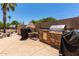 Outdoor kitchen with a built-in grill and a fireplace at 1231 N Layman St, Gilbert, AZ 85233