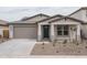 Inviting single-story home with a two-car garage and a well-manicured, low-maintenance front yard at 12722 W Luxton Ln, Avondale, AZ 85323